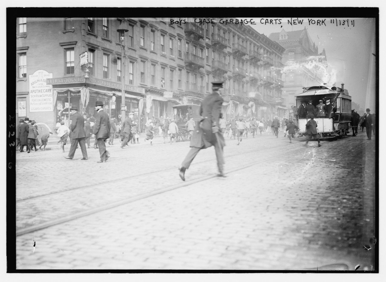 historicaltimes:Boys chase garbage carts, New York, 1911 via reddit