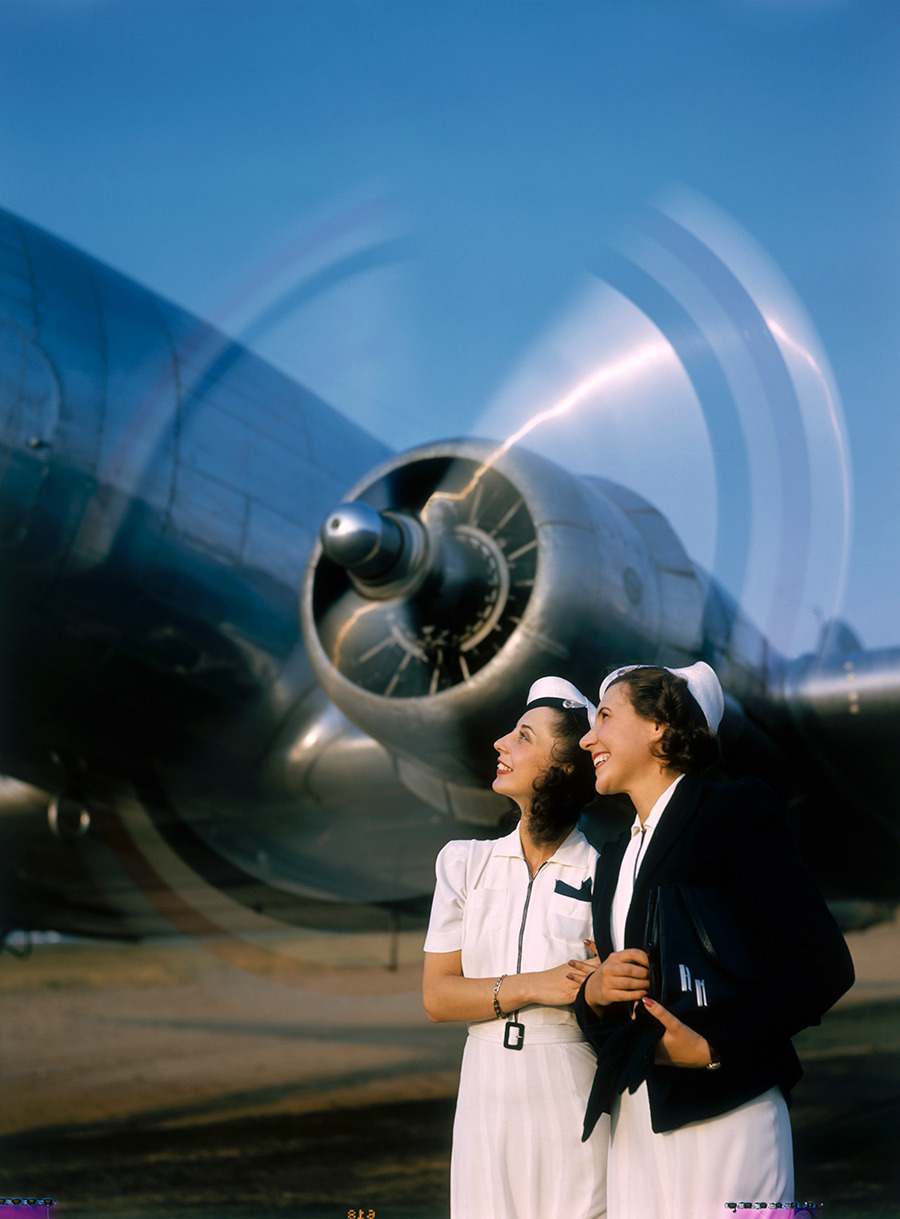 Two young women stand near a turning aircraft propeller, 1940.Photograph by Luis Marden, National Geographic Creative