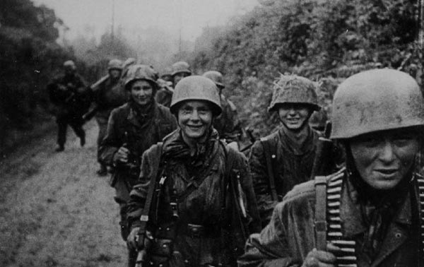 A Famous Photo (from a Newsreel) of 10./Fallschirmjäger Regiment 6 in Normandy full of young faces, including Gefreiter Georg Schober (center looking directly at camera). I never knew what Unit of FJR6 they belonged to till I read ‘Lions Of Carentan’ which had another photo from the newsreel with the man at the front right cut off.
