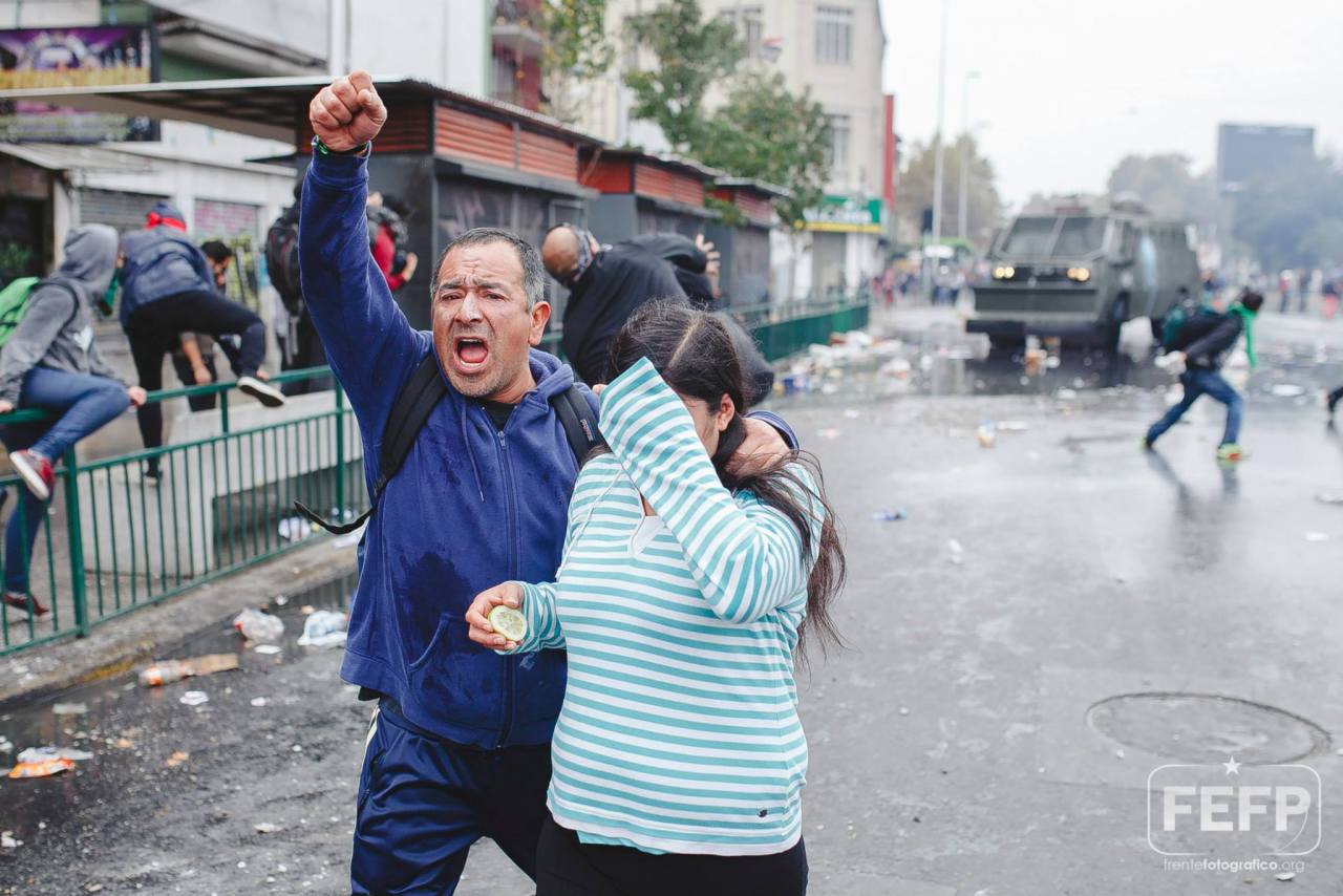 1 de Mayo. Santiago, Chile. / Una pareja de manifestantes resiste los gases lagrimógenos lanzados por la policía militarizada al finalizar la marcha por el Día del Trabajador.