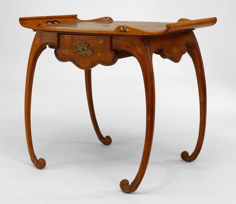 French art nouveau walnut serving table with inlaid floral design by Émile Gallé. From here.