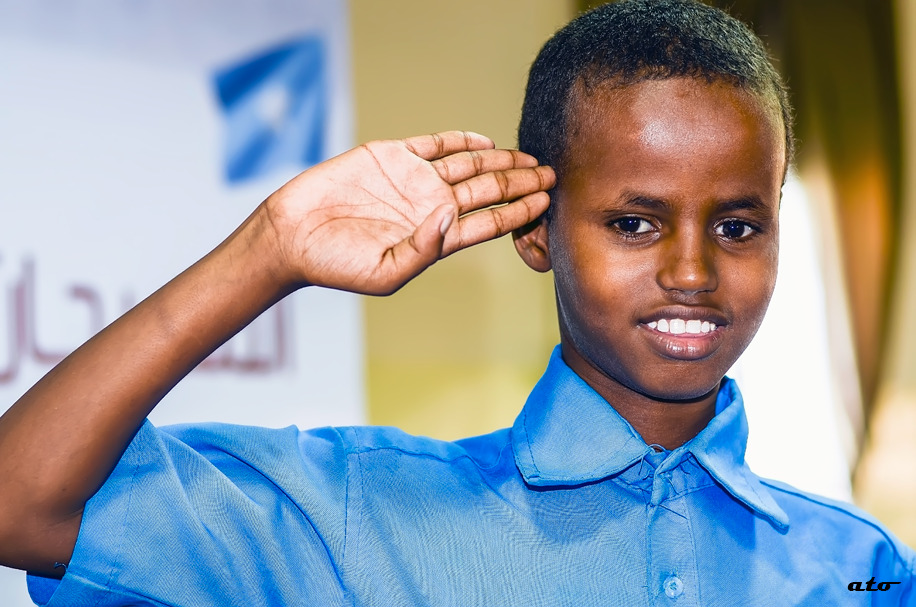 Students from Abdiaziz Primary salute the flag.