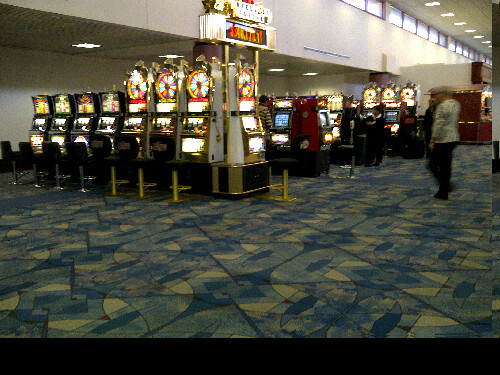 Last chance for gambling before leaving Nevada by air: slot machines at airport international terminal 2, attended by a cashier offering change. Presumably few people leave with bags of coins. (Las Vegas McCarran Airport) 20110416&#160;1015