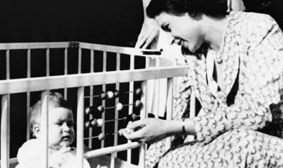 Princess Elizabeth in 1949 amusing her 8-month-old son, Prince Charles, by counting with the abacus on the side of his crib at Windlesham Moor. (AP)